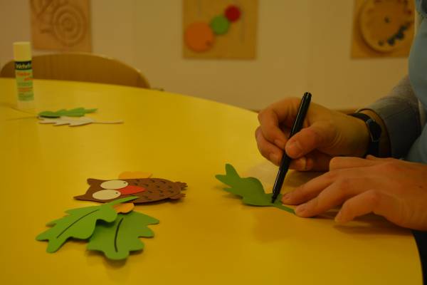 Conny bastelt aus Papier eine Eule