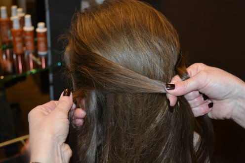 Von der linken Seite wird aus dem äußeren Bereich eine dünne Haarsträhne abgeteilt