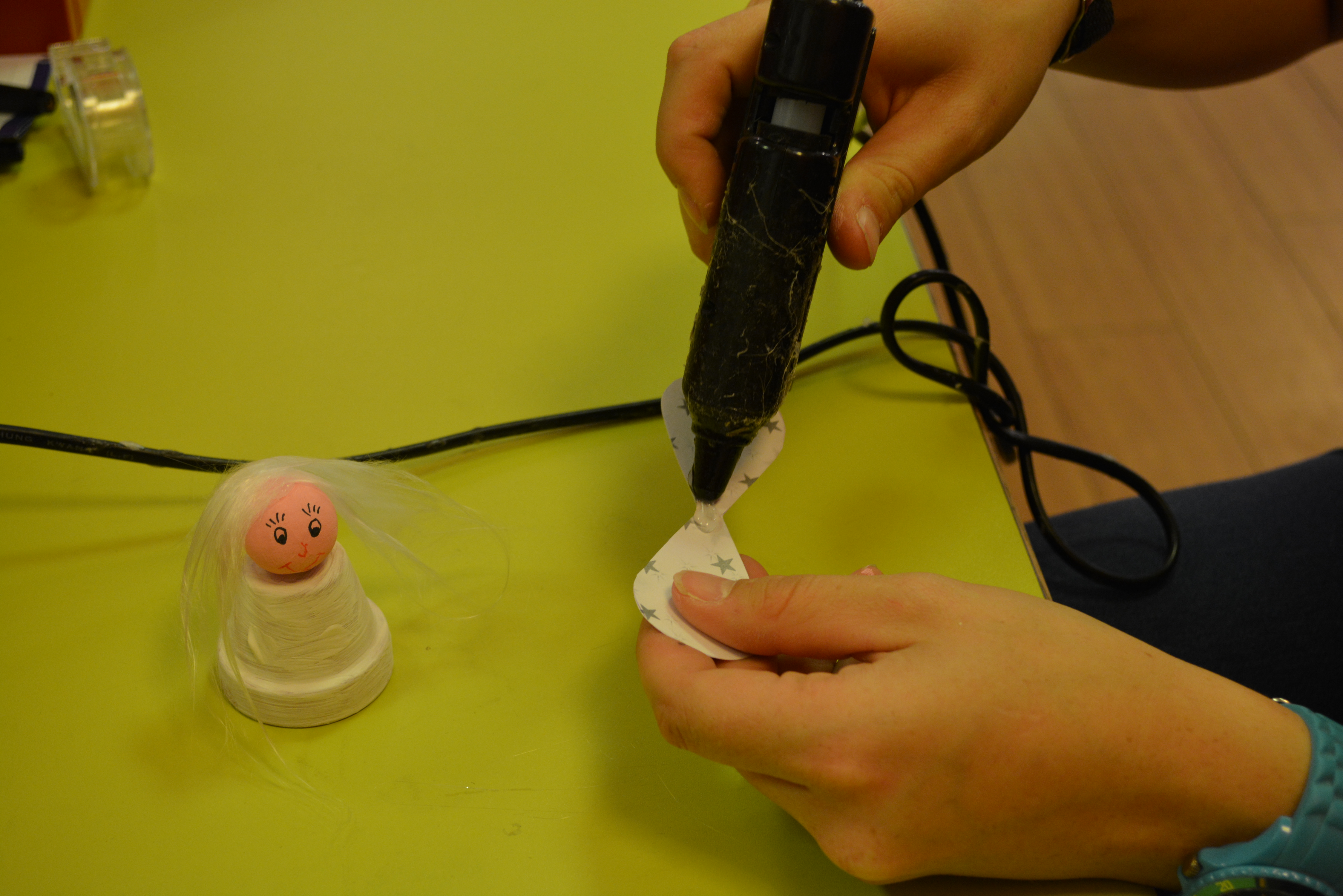Flügel mit Heißklebepistole am Tontopf befestigen